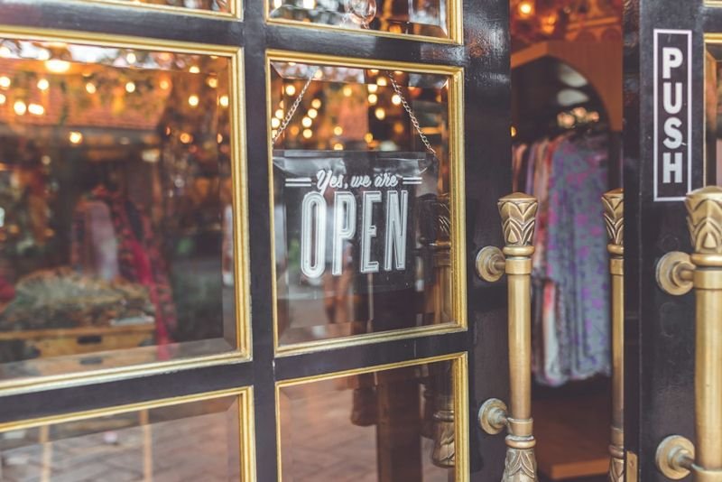 Vitrine d'une boutique avec un panneau « ouvert »